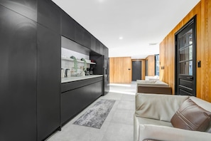 A modern kitchen with dark cabinetry, a white countertop, and a built-in oven.