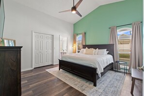 A bedroom with a bed, a ceiling fan, a window with curtains, and a door. - Amazing 3/2 vacation home with private pool!! (Davenport)