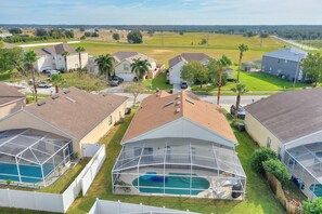 A residential area with houses, a swimming pool, and a large open field in the background. - Amazing 3/2 vacation home with private pool!! (Davenport)