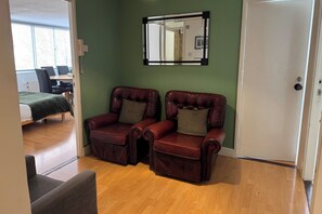 A room with two leather armchairs, a mirror, and a door. - 4 Bedroom Apartment Sleeps 14 With Balcony (London)