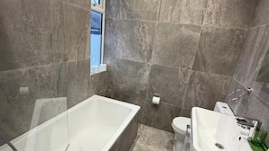 Une salle de bain avec une baignoire, des toilettes et un lavabo.