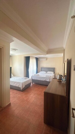 Habitación de hotel con dos camas, un aparador de madera, un espejo y una lámpara en el techo.
