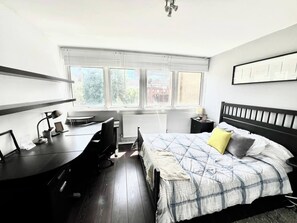Ein Schlafzimmer mit einem Bett, einem Schreibtisch und einer Heizung.
