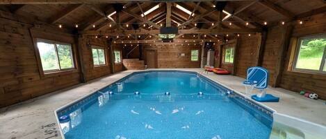 An indoor swimming pool with a 3FT depth marking, wooden walls, and a vaulted ceiling.