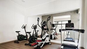Uma academia com bicicletas ergométricas, elípticos e esteira.