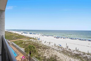 A beach view from a balcony with a pool, beach umbrellas, and lounge chairs. - Beachfront Paradise with Stunning Gulf Views, Island Echo Condo (Fort Walton Beach)