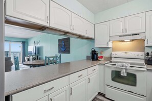 A kitchen with white cabinets, a countertop, and an oven. - Beachfront Paradise with Stunning Gulf Views, Island Echo Condo (Fort Walton Beach)