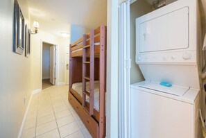 A laundry room with a washing machine and a bunk bed. - Disney Dreams Apartment Amazing Lake Views! (Orlando)