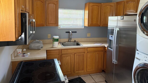 A kitchen with wooden cabinets, a stainless steel refrigerator, a built-in oven, and a washing machine. - 3/2:  Walk to River's Edge, Downtown Melbourne, and a hop over to the beach. (Melbourne)