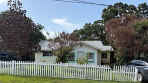 A single-story house with a white picket fence, a garage, and a driveway. - 3/2:  Walk to River's Edge, Downtown Melbourne, and a hop over to the beach. (Melbourne)