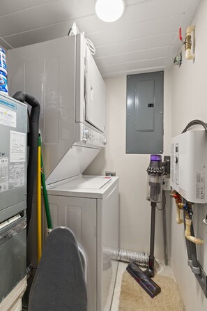A laundry room with a washing machine, dryer, and water heater. - Interlaken on the Coast - Beach Escape Awaits - Modern 2 Bedroom/2 Bathroom (Indian Rocks Beach)