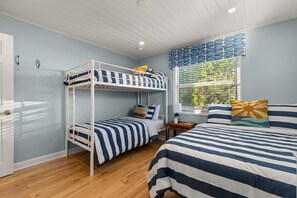 A room with bunk beds, a window with blinds, a bedside table, and a lamp. - Interlaken on the Coast - Beach Escape Awaits - Modern 2 Bedroom/2 Bathroom (Indian Rocks Beach)