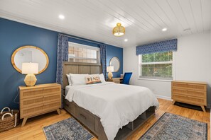 A bedroom with a bed, bedside tables, a dresser, a window with blinds, and a ceiling light fixture. - Interlaken on the Coast - Beach Escape Awaits - Modern 2 Bedroom/2 Bathroom (Indian Rocks Beach)