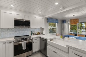A modern kitchen with white cabinetry, a stainless steel range, and a dishwasher. - Interlaken on the Coast - Beach Escape Awaits - Modern 2 Bedroom/2 Bathroom (Indian Rocks Beach)