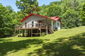 A two-story house with a red roof and a wooden deck. - Little Rock Creek Cottage on Trout Stream (Bakersville)