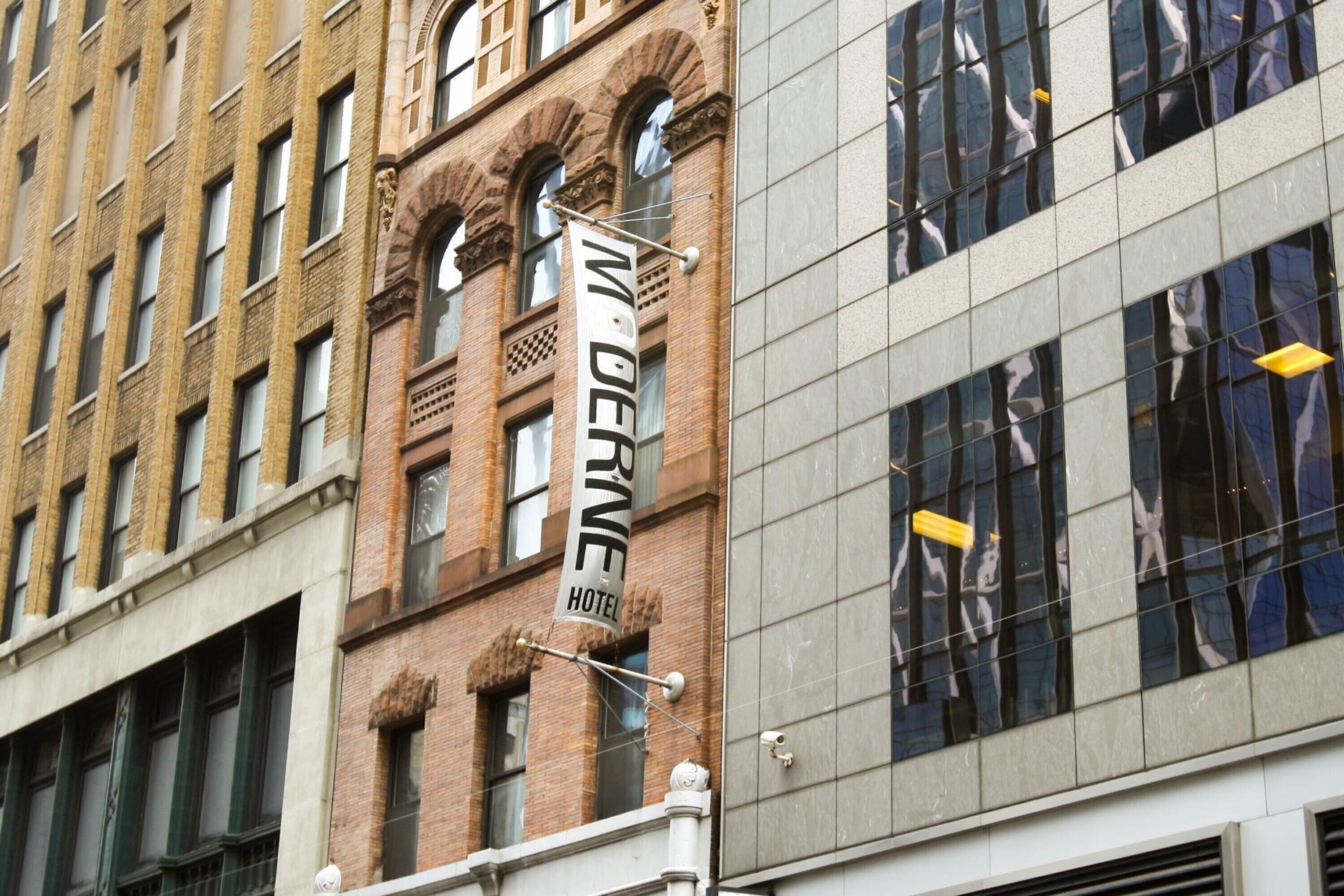 A hotel sign with the name 'MIDDLE' and a modern building with reflective windows.