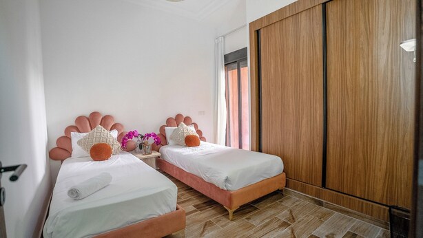 Un dormitorio con dos camas, un armario y una ventana con cortinas.