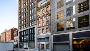 En bygning i flere etager med forskellige arkitektoniske stilarter, blandt andet en murstensfacade og store vinduer.