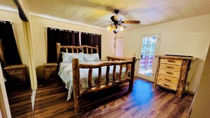 A bedroom with a wooden bed, a ceiling fan, a wooden dresser, and a window with blinds. - Pet-Friendly 3-Bed Retreat near Shasta Lake with cozy wood stove (Lakehead)