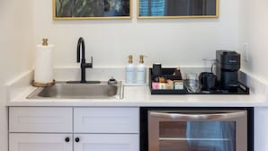 Uma cozinha moderna com uma pia de aço inoxidável, uma cafeteira e uma máquina de lavar louça.