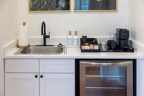 Una cocina moderna con un lavamanos de acero inoxidable, una cafetera y un lavavajillas.