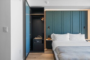 Quarto moderno com cama, mesas de cabeceira, guarda-roupa e closet embutido.