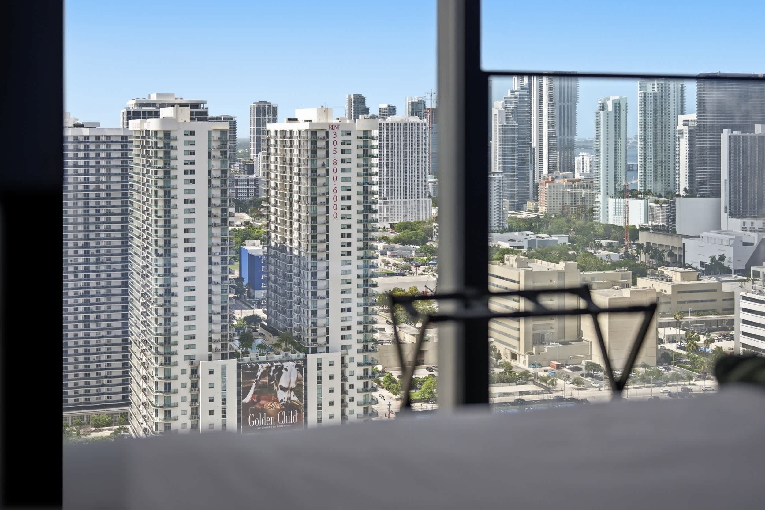 Un immeuble de grande hauteur offrant une vue dégagée sur le paysage urbain, visible à travers une fenêtre.