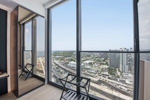 A high-rise apartment with large floor-to-ceiling windows offering a city view. - Experience The Brand New E11EVEN Residences (Miami)