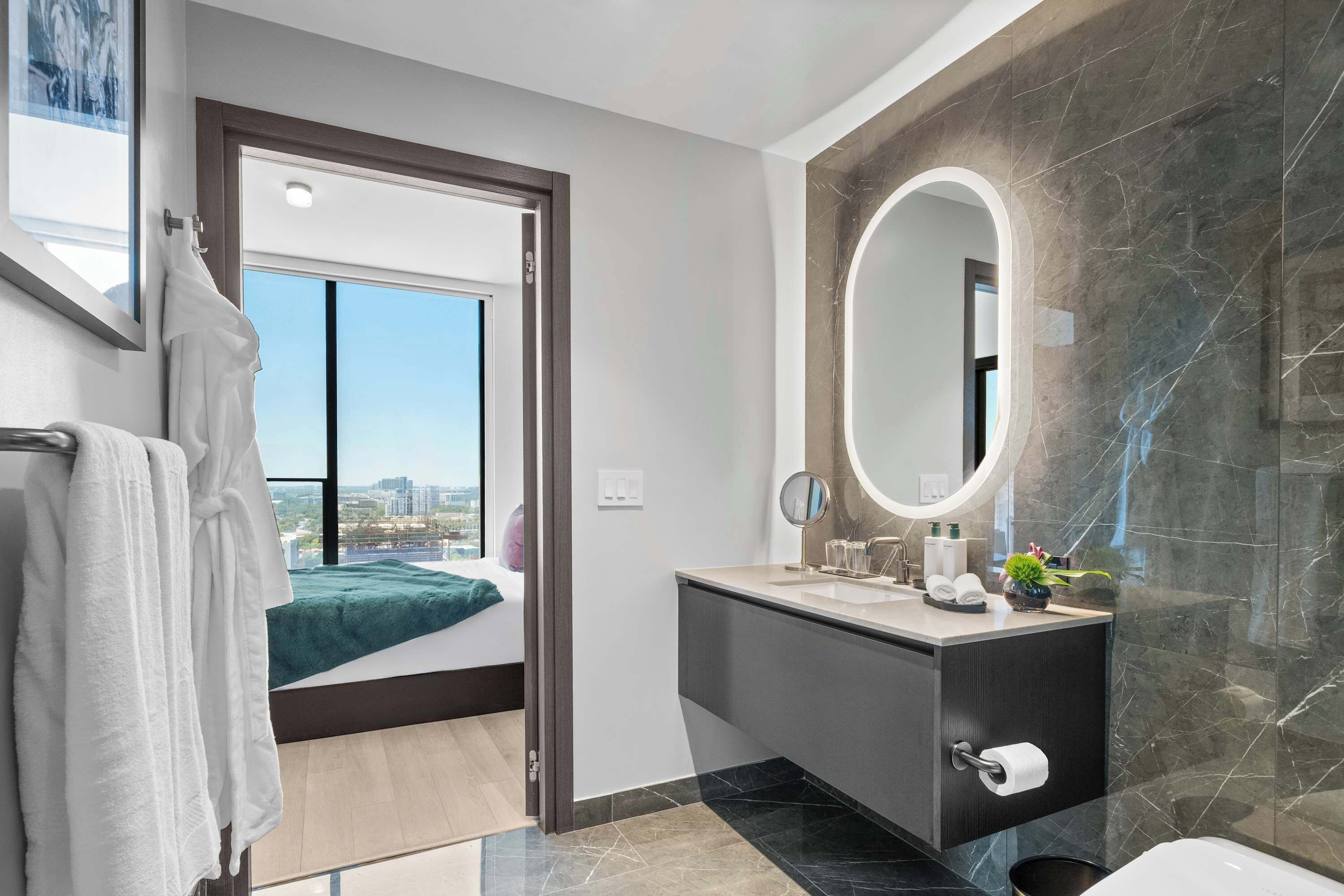Une salle de bain moderne avec un grand miroir, un lavabo et des toilettes.