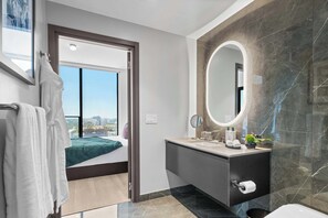 A modern bathroom with a large mirror, a sink, and a toilet. - Elite E11EVEN Suite Rooftop Pool and City Views (Miami)