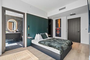 Quarto moderno com uma cama grande, um closet espaçoso e um banheiro com toucador de mármore.