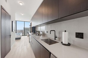 A modern kitchen with a large window, a sink, and a toilet paper holder. - Luxury E11EVEN Studio Resort Pool Elite Amenities (Miami)