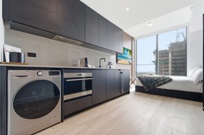 Eine moderne Küche mit eingebauten Geräten, einem großen Fenster und Blick auf die Stadt.