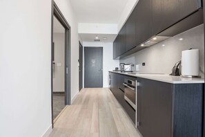 Eine moderne Küche mit Kochinsel, integrierten Geräten und schlichtem Design.