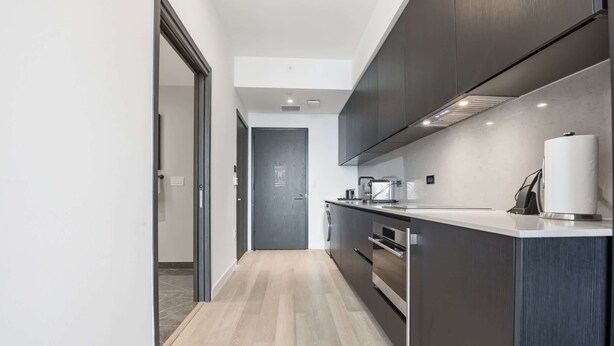 Een moderne keuken met een centraal eiland, inbouwapparatuur en een minimalistisch ontwerp.