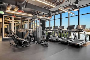 Ein Fitnessstudio mit Laufbändern, Kraftgeräten und Spiegeln.