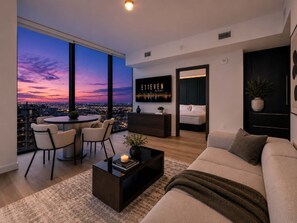 Ein modernes Wohnzimmer mit Blick auf die Stadt, einem Essbereich und einer gemütlichen Sitzecke.
