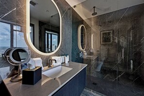 Un baño moderno con un espejo grande, un lavabo y una zona de ducha.