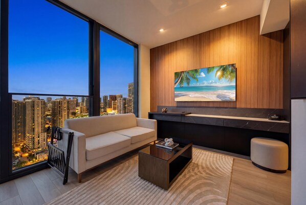 Una sala de estar moderna con un ventanal grande, un sofá, una mesa de centro y un cuadro de una escena de playa.