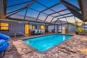 A swimming pool with a covered patio area, outdoor furniture, and a view of the surrounding landscape. - Gorgeous 4 Bedroom Home with Private Pool and Full Kitchen in Rotonda West (Rotonda West)