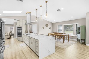 A modern kitchen with a central island, built-in appliances, and pendant lighting. - Gorgeous 4 Bedroom Home with Private Pool and Full Kitchen in Rotonda West (Rotonda West)