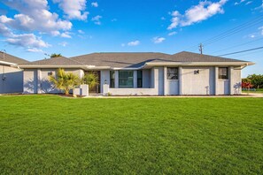 A single-story house with a front lawn, a garage, and a driveway. - Gorgeous 4 Bedroom Home with Private Pool and Full Kitchen in Rotonda West (Rotonda West)