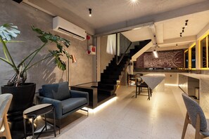 A modern interior with a staircase, seating area, and a map on the wall. - Neo Red Studio @ Saigon's alley with Rooftop Onsen (Thành phố Hồ Chí Minh)