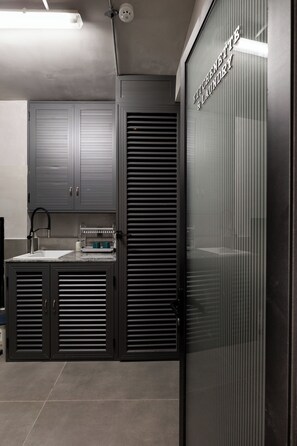 A modern kitchen with a sink, cabinets, and a countertop. - Neo Red Studio @ Saigon's alley with Rooftop Onsen (Thành phố Hồ Chí Minh)