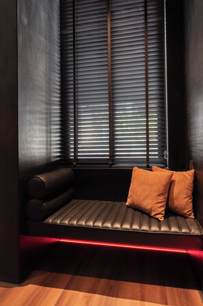 A dark room with a bench and a window with blinds. - Neo Red Studio @ Saigon's alley with Rooftop Onsen (Thành phố Hồ Chí Minh)