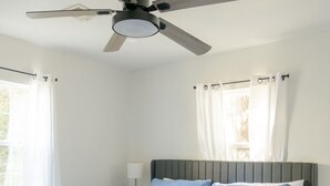 A bedroom with a bed, a ceiling fan, and curtains. - The Village 3BR (The Village)