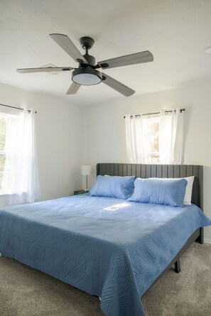 A bedroom with a bed, a ceiling fan, and curtains. - The Village 3BR (The Village)