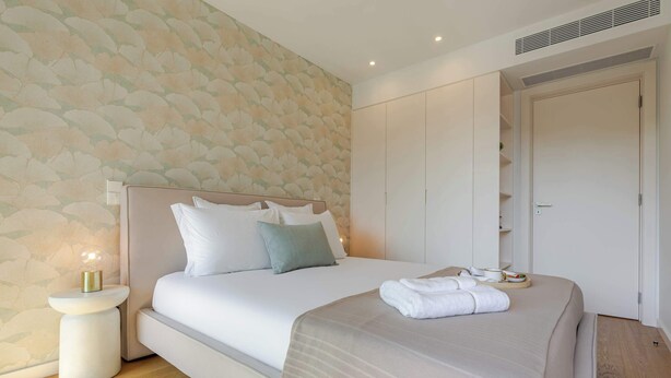 Ein Schlafzimmer mit Bett, Nachttisch und Kleiderschrank.