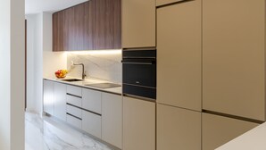 Eine moderne Küche mit Marmorarbeitsplatte, einem Spülbecken und eingebauten Geräten.