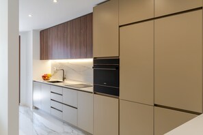 Eine moderne Küche mit Marmorarbeitsplatte, einem Spülbecken und eingebauten Geräten.